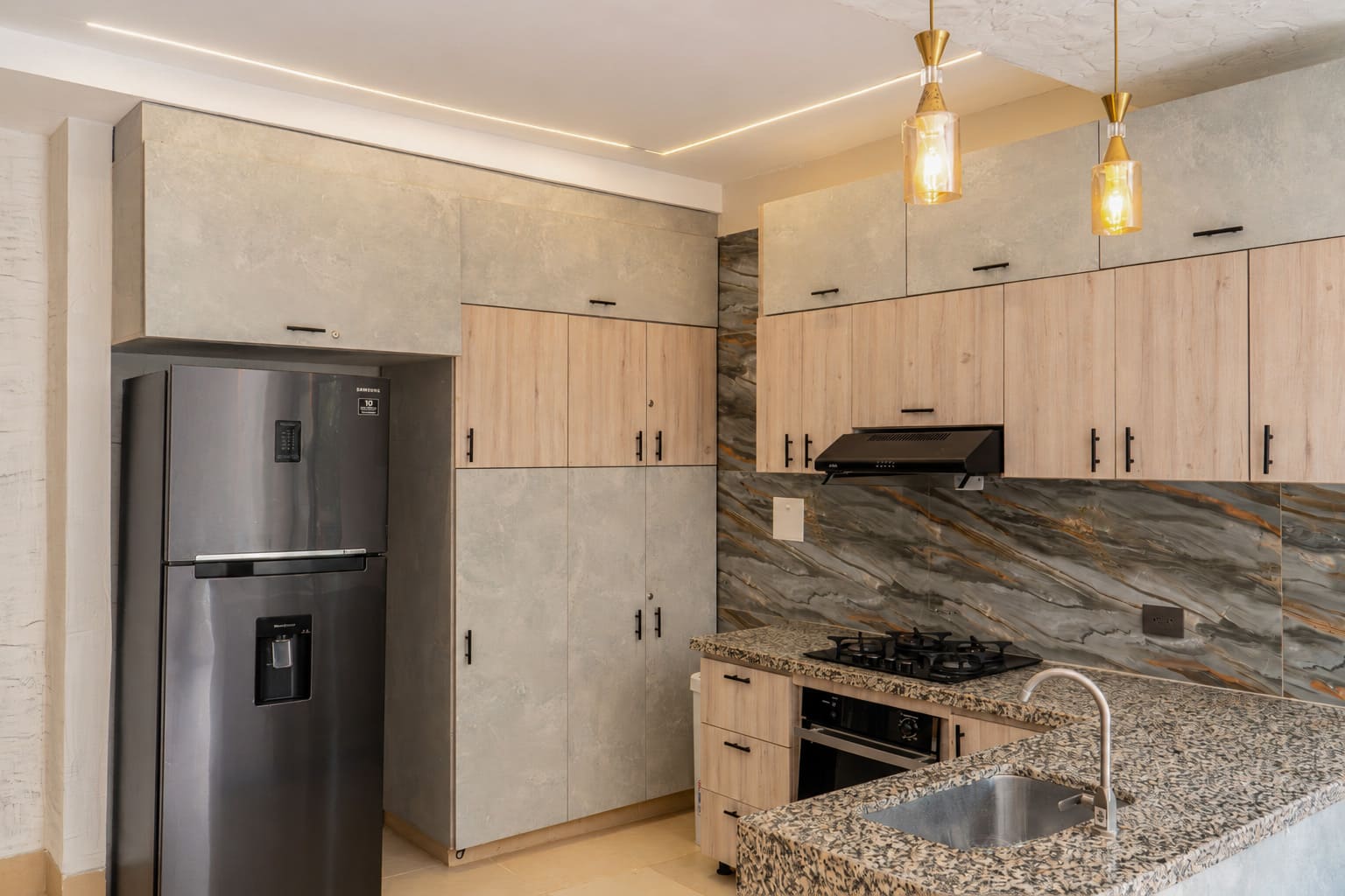 Cocina con refrigerador y mármol